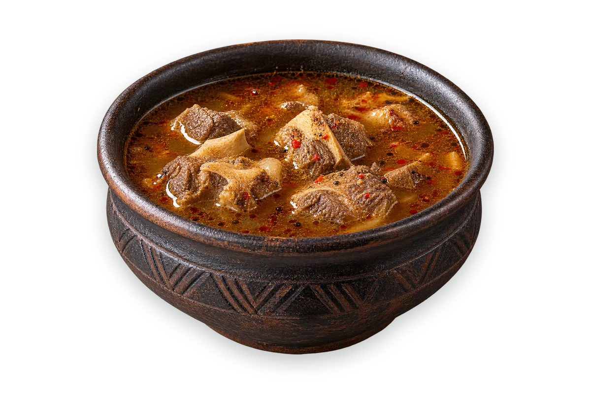 Pepper soup with oxtail in a dark clay bowl